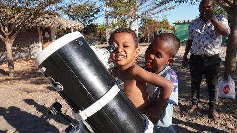 Des enfants malgaches regardant dans un télescope avec l'association Haikintana. 